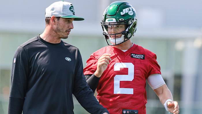 Zach Wilson talks with quarterbacks coach Rob Calabrese during his first practice with the Jets